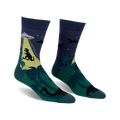 Crew socks in dark blue, green, and yellow. The design features a T-Rex, UFO, palm trees, and pterodactyls.