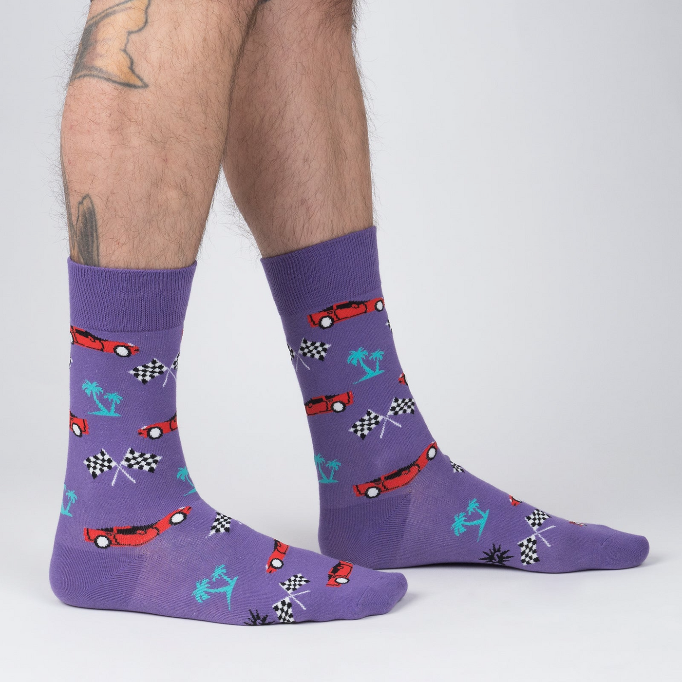 Lifestyle shot of a man's legs wearing the 'You Drive Me Crazy' socks, showcasing the fit and style.
