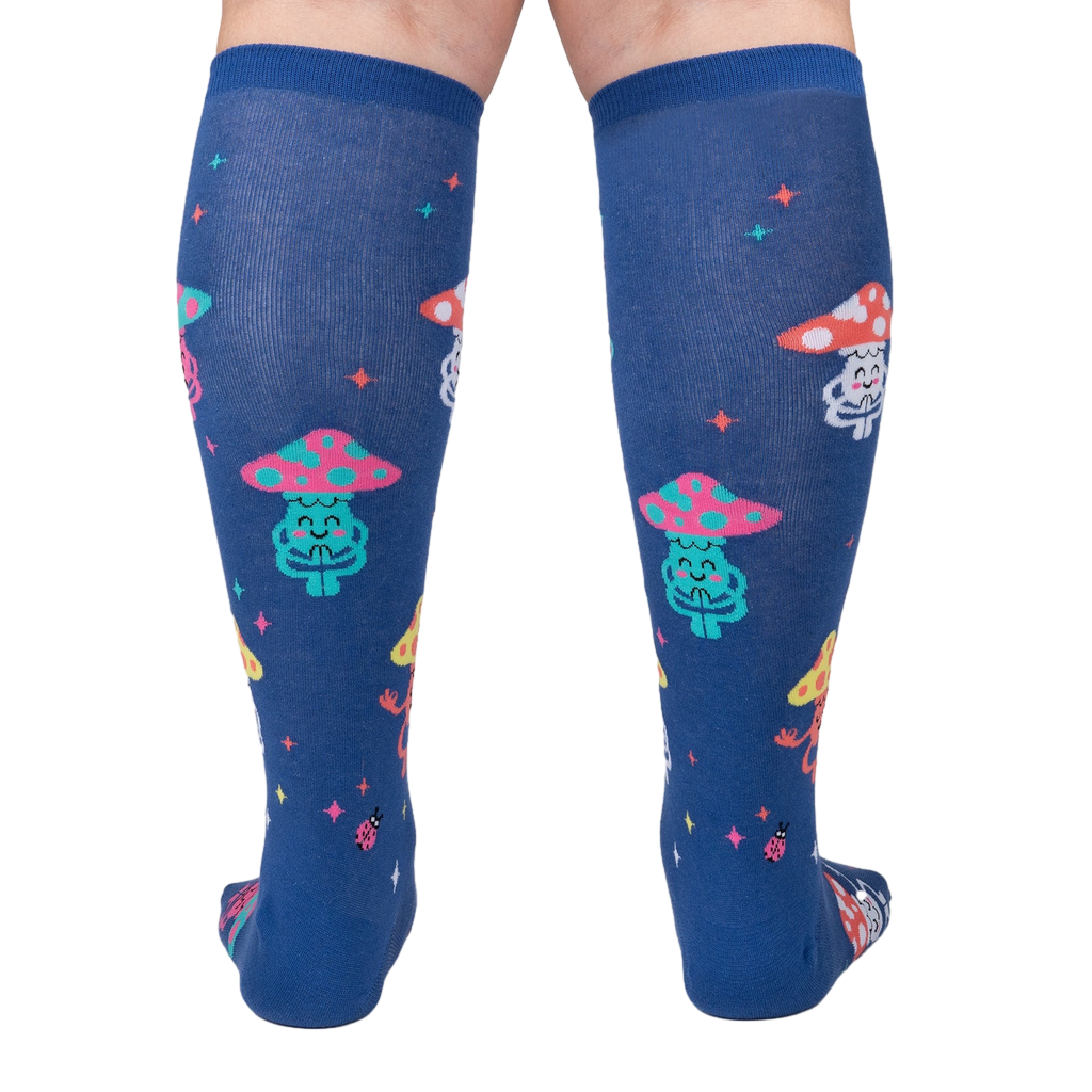 Rear view of a person wearing the navy blue knee-high socks with meditating mushrooms.