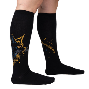 Lifestyle shot showing the Night Cat knee-high socks on a person's legs, showcasing the fit and design.