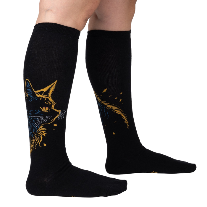 Lifestyle shot showing the Night Cat knee-high socks on a person's legs, showcasing the fit and design.