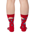 Back view of a person wearing a pair of red crew socks with armadillo and cacti print.