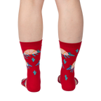 Back view of a person wearing a pair of red crew socks with armadillo and cacti print.