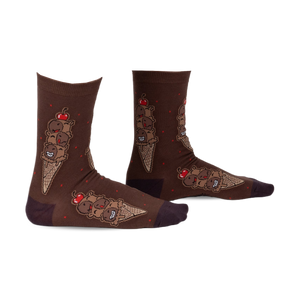 Pair of brown crew socks featuring a whimsical ice cream cone design with chocolatey characters and red cherries. 
