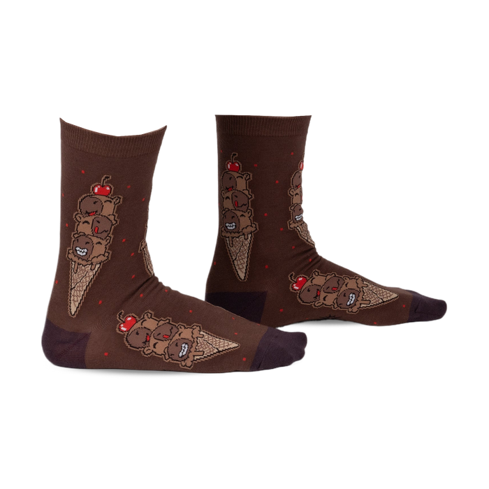Pair of brown crew socks featuring a whimsical ice cream cone design with chocolatey characters and red cherries. 