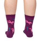 Back view of a person wearing Relaxolotl socks, showcasing the axolotl and fern pattern.