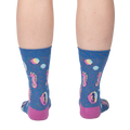Back view of model wearing a pair of blue crew socks with seahorse and bubble design.