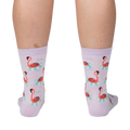 Back view of a person wearing lavender crew socks featuring a repeating pattern of flamingos on inflatable rings.