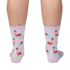 Back view of a person wearing lavender crew socks featuring a repeating pattern of flamingos on inflatable rings.