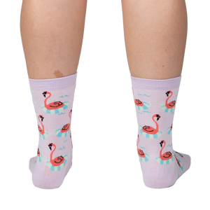 Back view of a person wearing lavender crew socks featuring a repeating pattern of flamingos on inflatable rings.