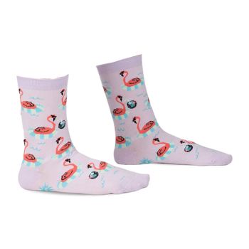 Pair of light purple crew socks with a repeating pattern of orange flamingos floating in blue inner tubes on wavy water.