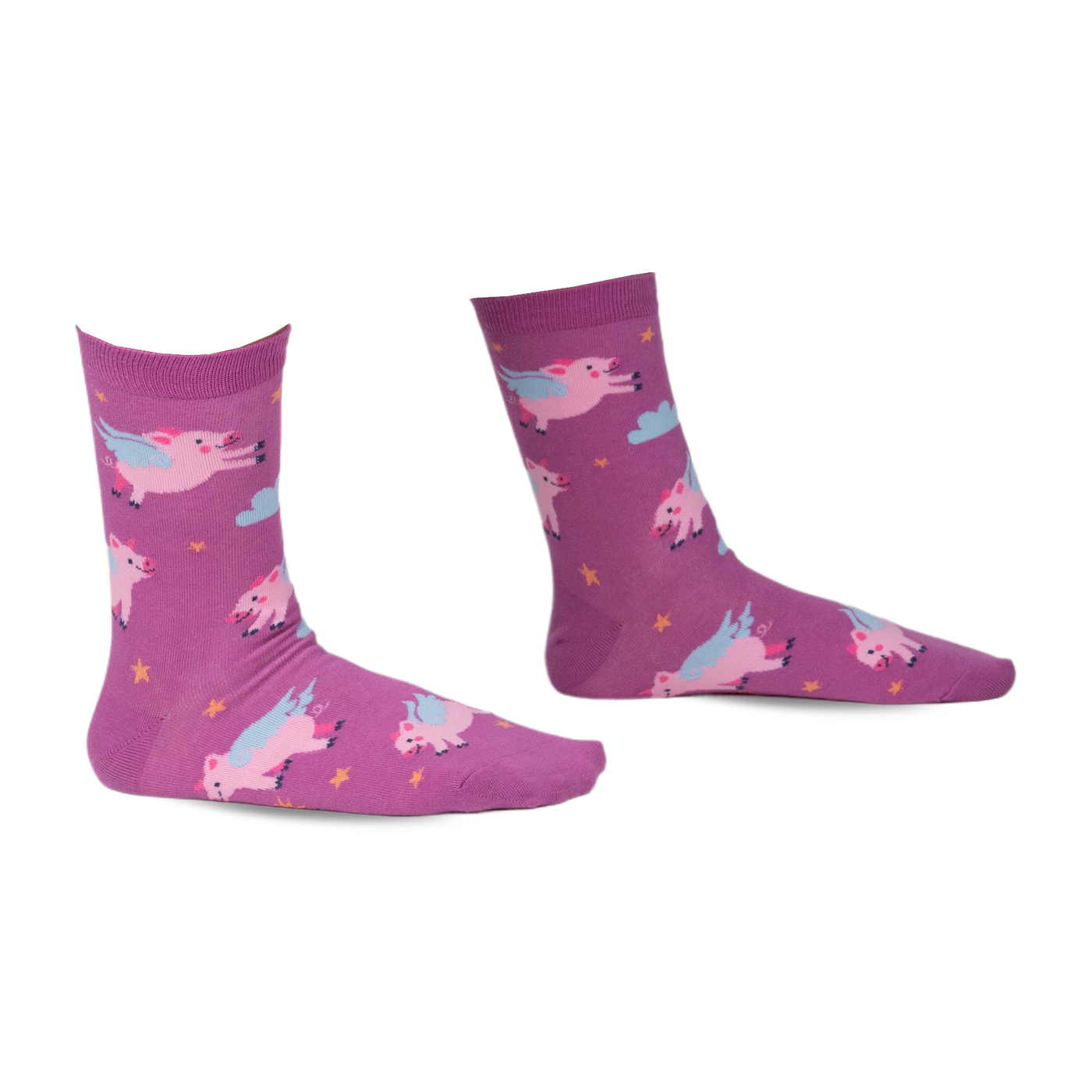 Pair of purple crew socks with a whimsical design of pink pigs with wings flying amongst yellow stars and clouds.