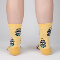 Lifestyle shot of a person's legs wearing the 'I Just Love Raccoons and Ramen' socks.