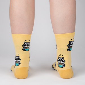 Lifestyle shot of a person's legs wearing the 'I Just Love Raccoons and Ramen' socks.