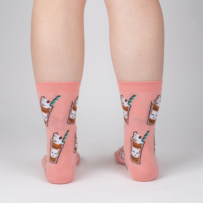 Back view of Cat-puccino socks on a person's legs, showcasing the full design on the socks against a light background.