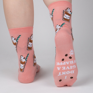 Close-up shot of the back of Cat-puccino socks. The socks have 'I DON'T GIVE A FRAPPE' text printed on the heel.