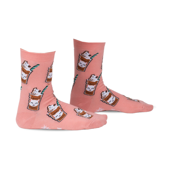 Pair of peach-colored crew socks with a repeating pattern of cartoon cats in coffee cups.  Features green straws and coffee bean accents.