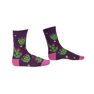 Pair of purple crew socks with a whimsical cactus and flower design. Pink accents at the heel and toe.