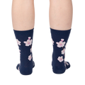 Back view of a person wearing navy blue crew socks with a pink cherry blossom pattern.