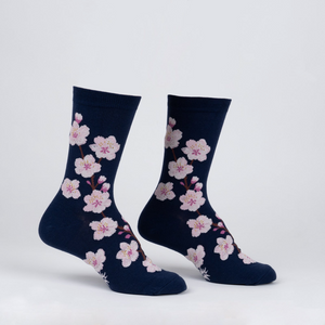 Another studio shot of the navy blue crew socks with pink cherry blossoms, showcasing the design from a slightly different angle.