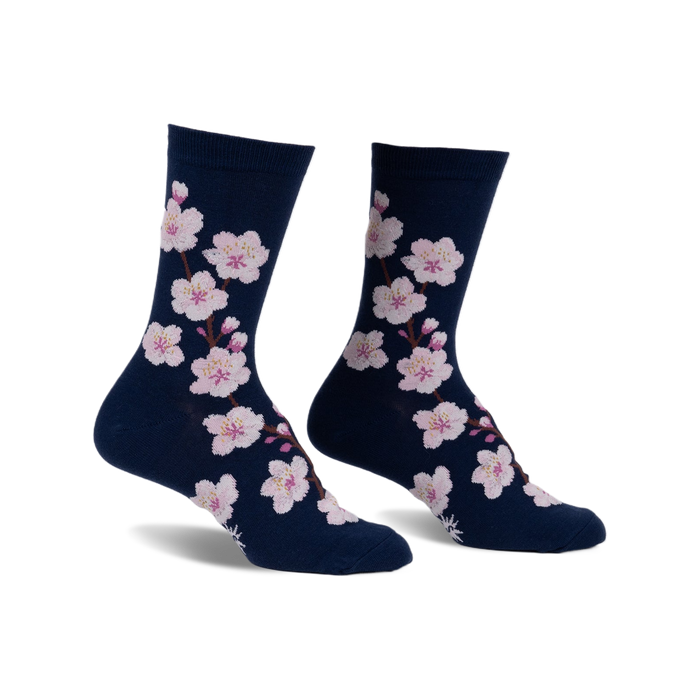 Pair of navy blue crew socks adorned with a pattern of pink cherry blossoms. 