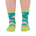 A person's legs and feet, viewed from the front, wearing the fuzzy teal blue slipper socks.