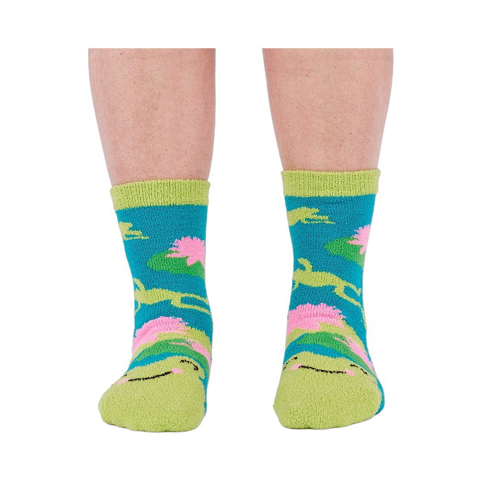 A person's legs and feet, viewed from the front, wearing the fuzzy teal blue slipper socks.