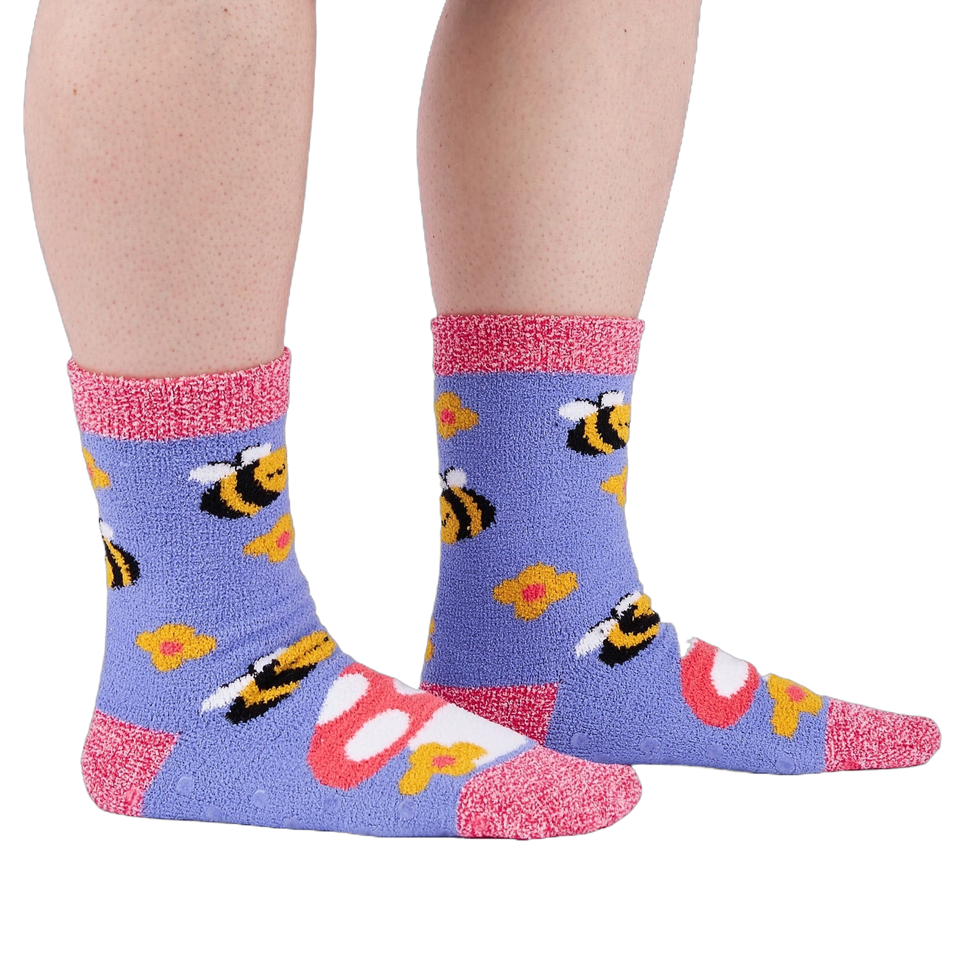 Person wearing fuzzy periwinkle slipper socks with bee, mushroom, and flower patterns, side view.