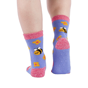 Person wearing fuzzy periwinkle slipper socks, back view, showing the anti-slip grippers on the sole.