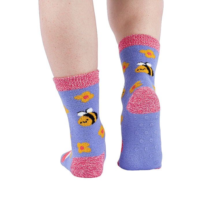Person wearing fuzzy periwinkle slipper socks, back view, showing the anti-slip grippers on the sole.