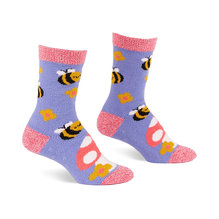 Pair of fuzzy periwinkle slipper socks with pink cuffs, heels, and toes, patterned with yellow bees, mushrooms, and flowers.