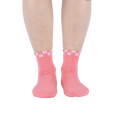 Another lifestyle shot showing the socks on a person's feet from a different angle. The socks are pink with a white and pink checkered cuff and embroidered daisy with an eye in the center.