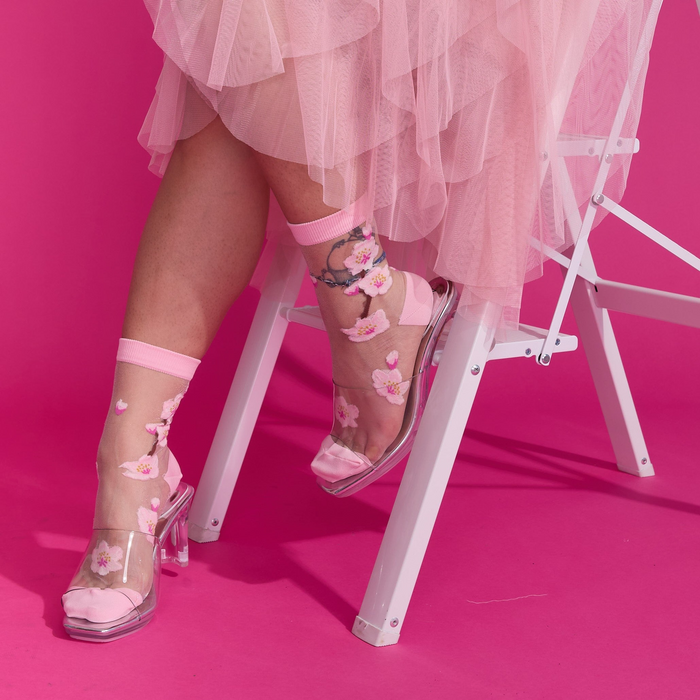 [lf] Model in pink tulle skirt and clear heels showcasing sheer cherry blossom socks.