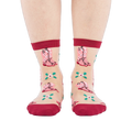 A person's legs and feet, wearing sheer pink cowboy boot socks, viewed from the front against a white background.