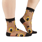 Person's lower legs and feet wearing the sheer black cat socks, standing on a white background.