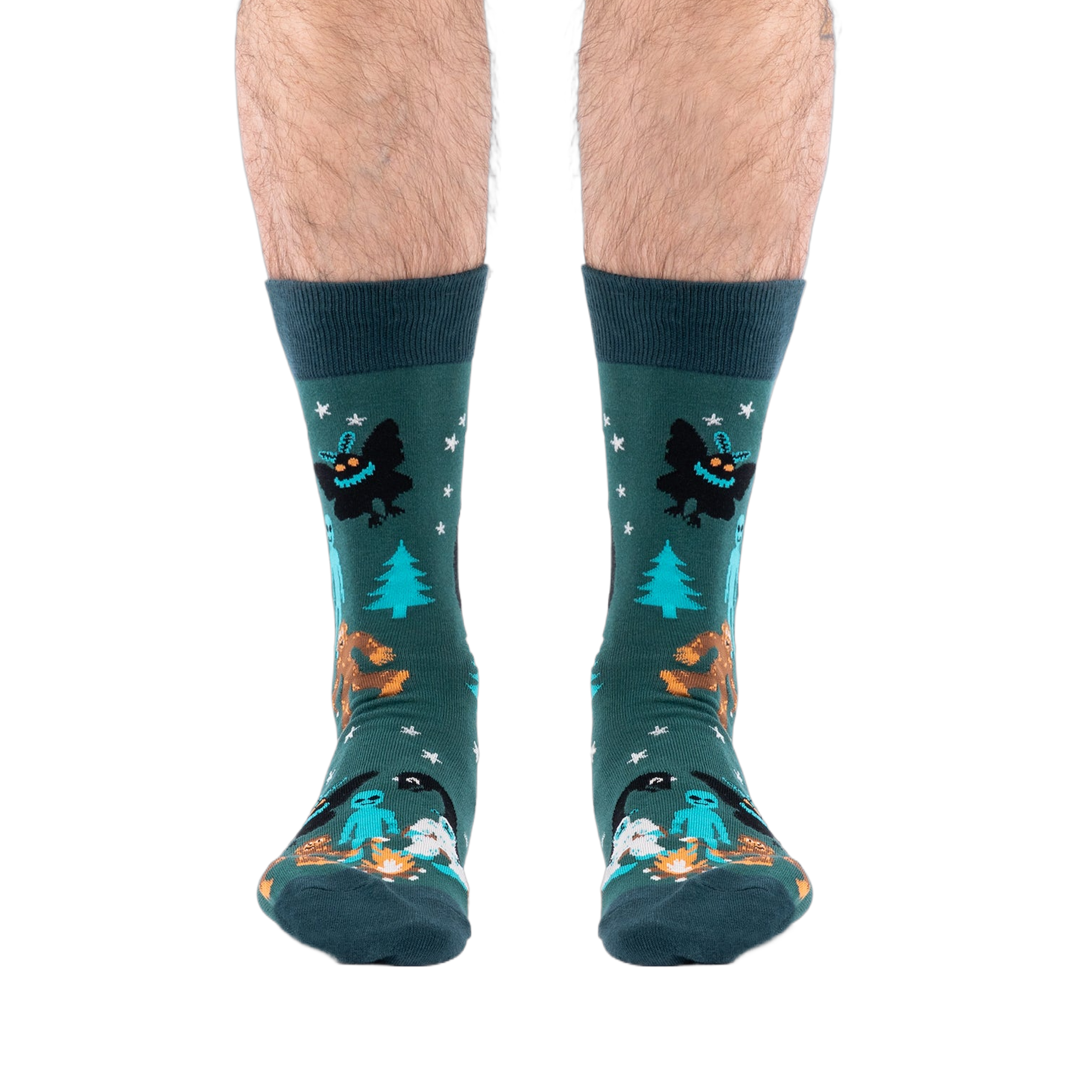 Front view of a person's lower legs, showing both dark green cryptid socks featuring Bigfoot and Mothman.