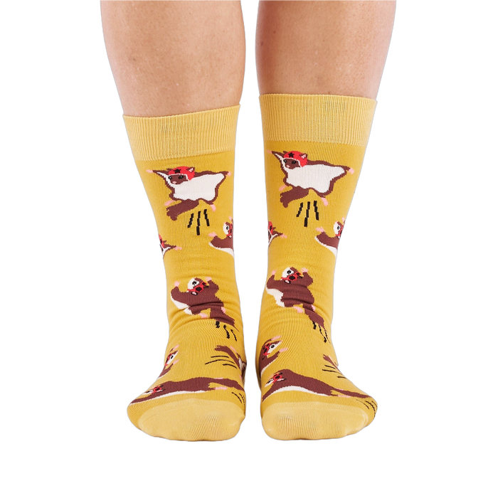 Person standing, wearing mustard yellow crew socks with flying squirrel pattern, viewed from the front.