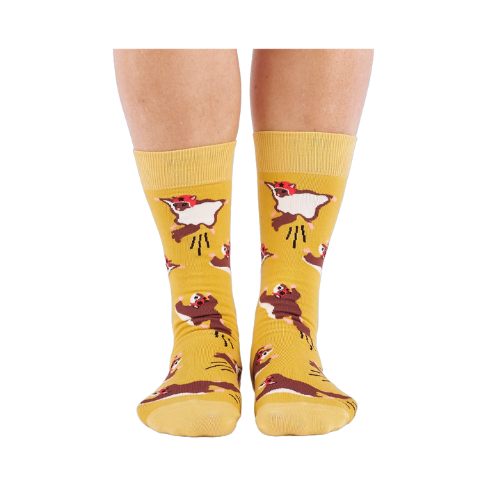 Person standing, wearing mustard yellow crew socks with flying squirrel pattern, viewed from the front.