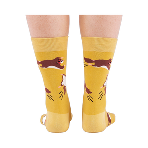 Person standing, wearing mustard yellow crew socks with flying squirrel pattern, viewed from the back.
