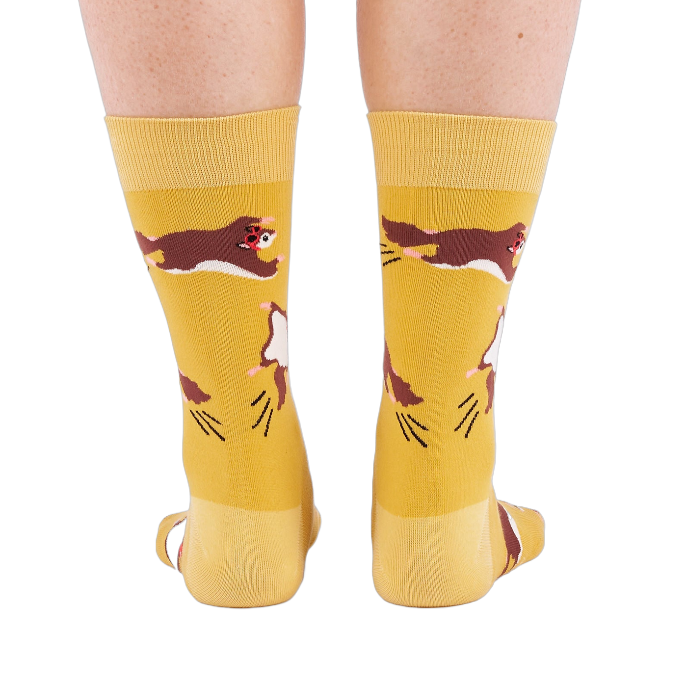 Person standing, wearing mustard yellow crew socks with flying squirrel pattern, viewed from the back.