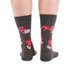 Full-length shot of a person's legs, viewed from the back, wearing grey axolotl gaming crew socks on a white background.