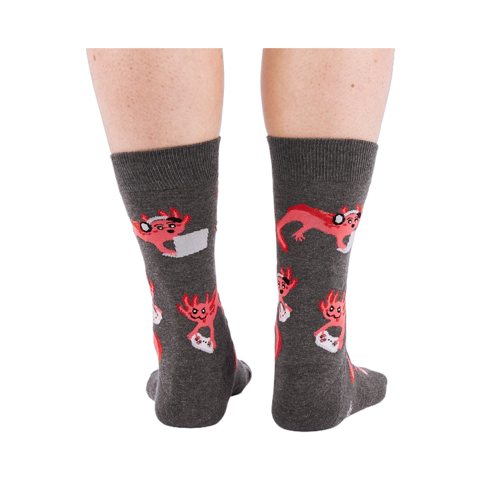 Full-length shot of a person's legs, viewed from the back, wearing grey axolotl gaming crew socks on a white background.