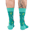 Back view of a person wearing teal fly fishing socks, showing leg hair and tattoos on both calves.