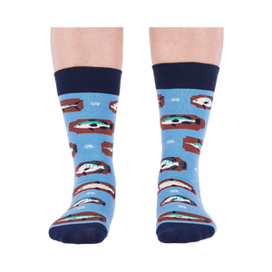 Person standing forward wearing light blue crew socks with fish and knot patterns on a white background.