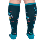 Back view of calves wearing dark teal knee-high socks, showing colorful music notes, pink roses, and blue ticket graphics.