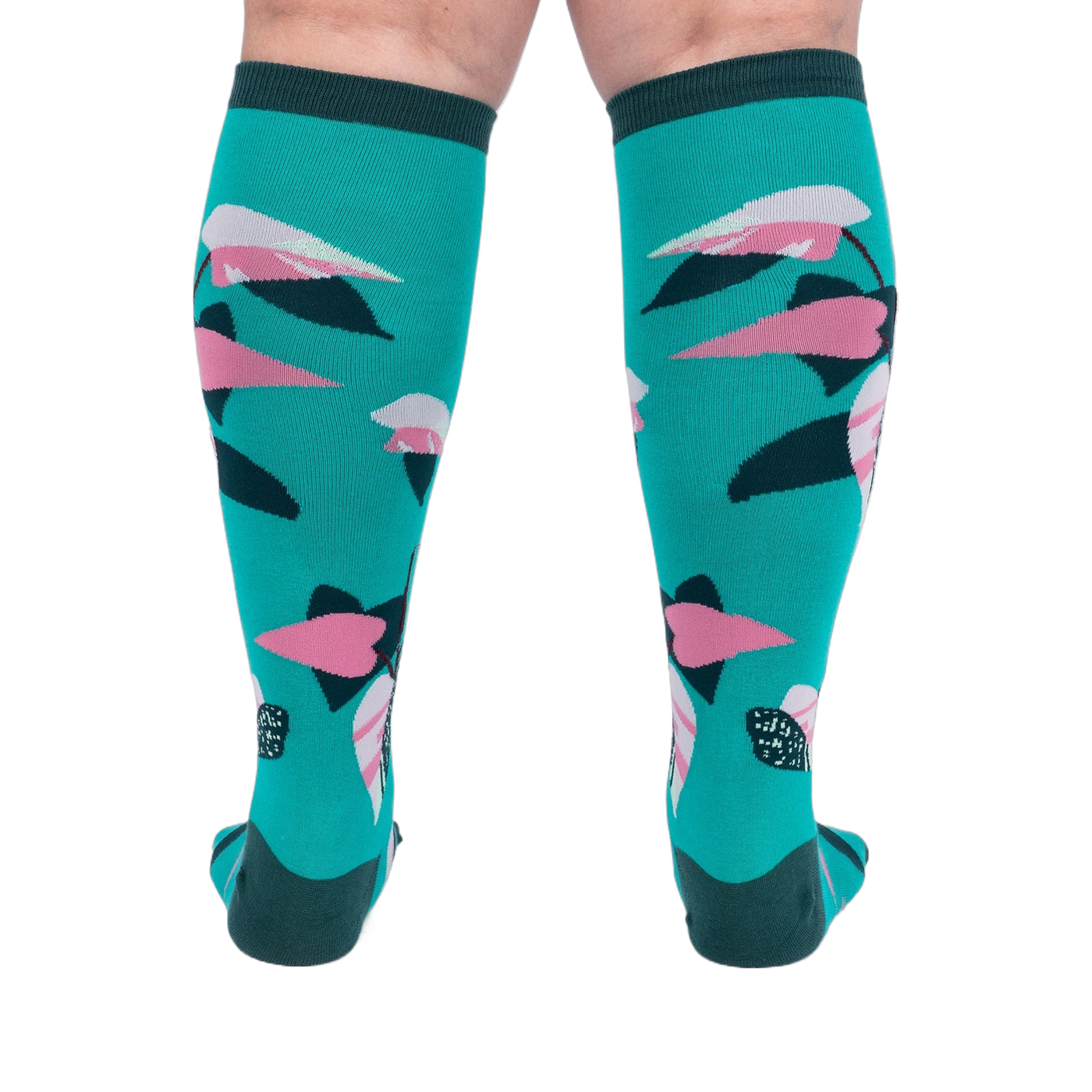 Back view of a person's legs wearing teal knee-high socks with pink and dark green philodendron leaves.
