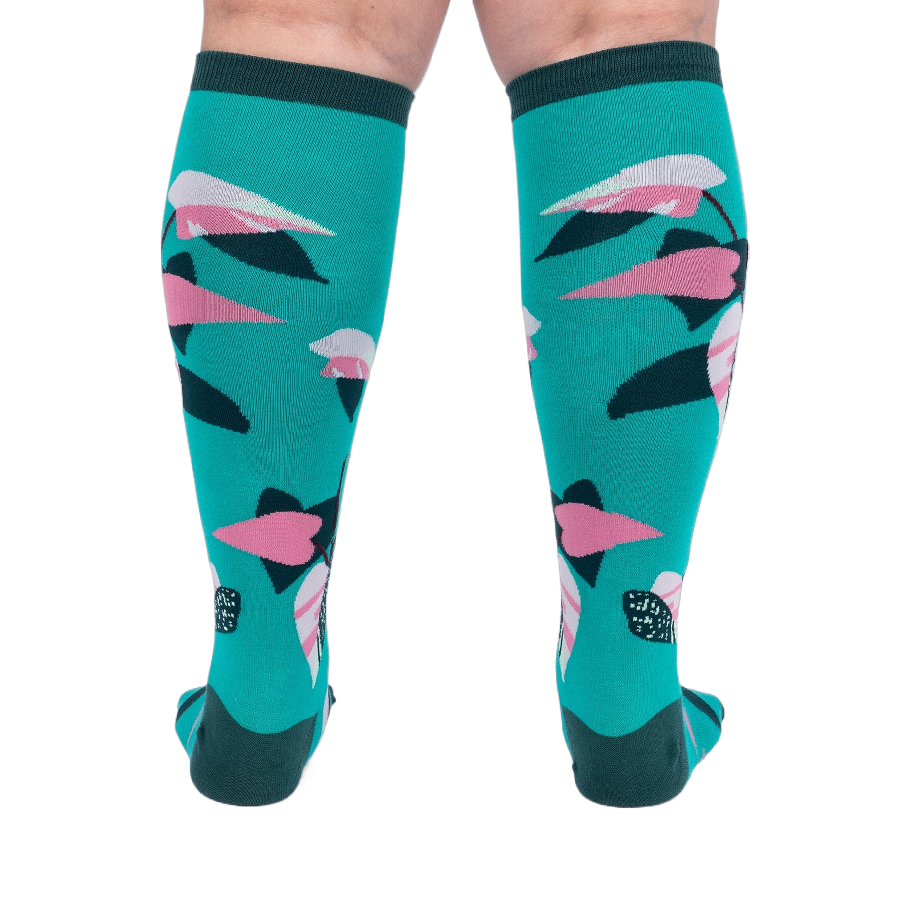 Back view of a person's legs wearing teal knee-high socks with pink and dark green philodendron leaves.