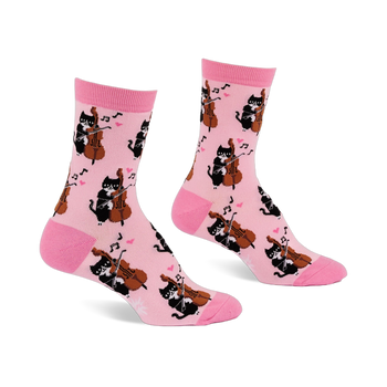 Pair of light pink crew socks with a repeating pattern of black cats playing string instruments, pink hearts, and music notes.