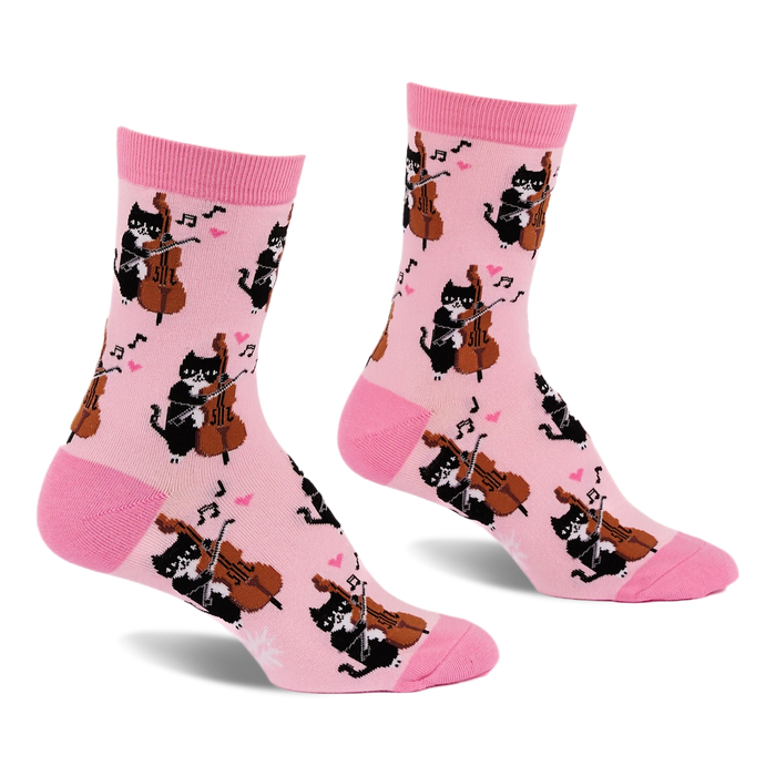 Pair of light pink crew socks with a repeating pattern of black cats playing string instruments, pink hearts, and music notes.