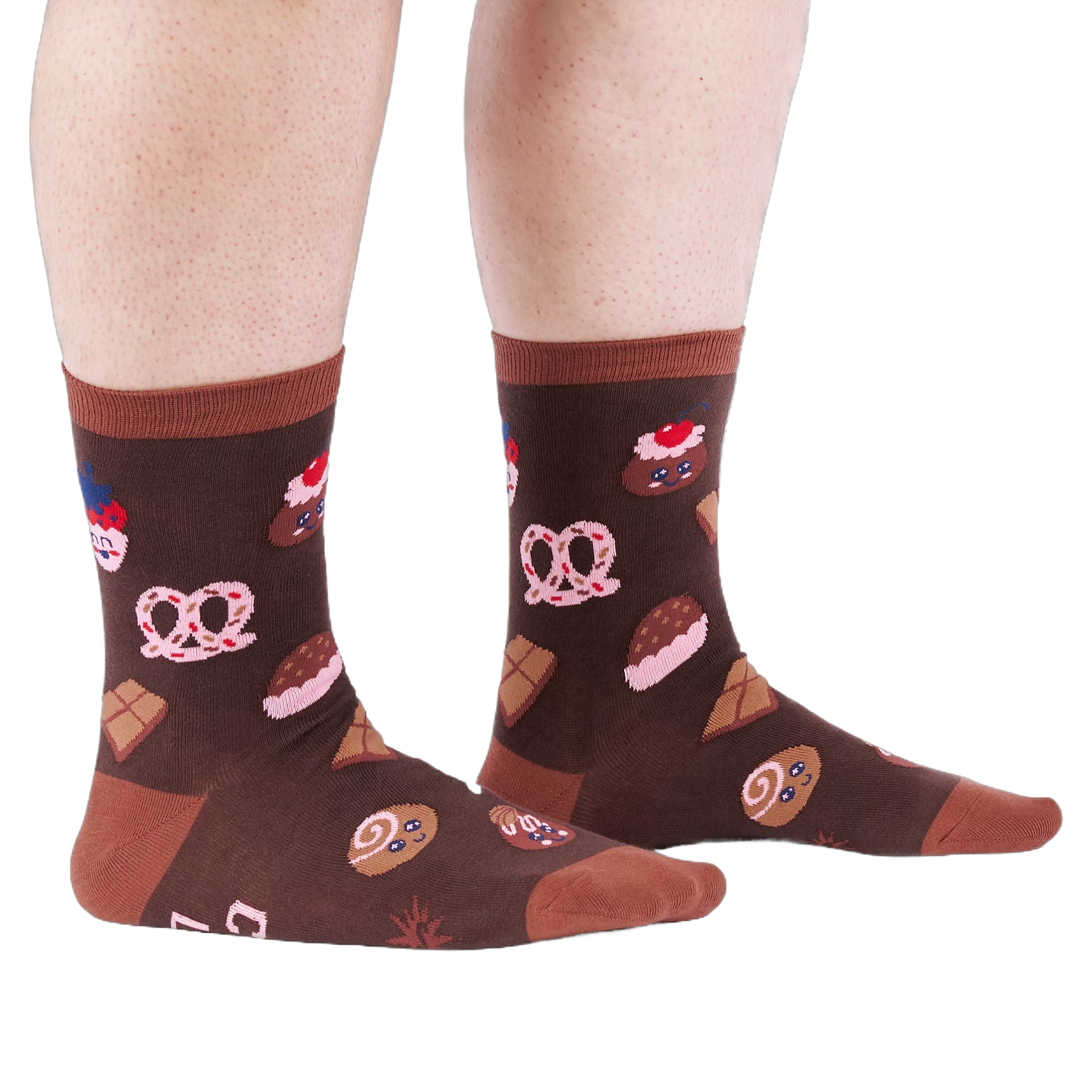 Person standing on a white floor, wearing brown crew socks patterned with cupcakes, pretzels, and chocolate.